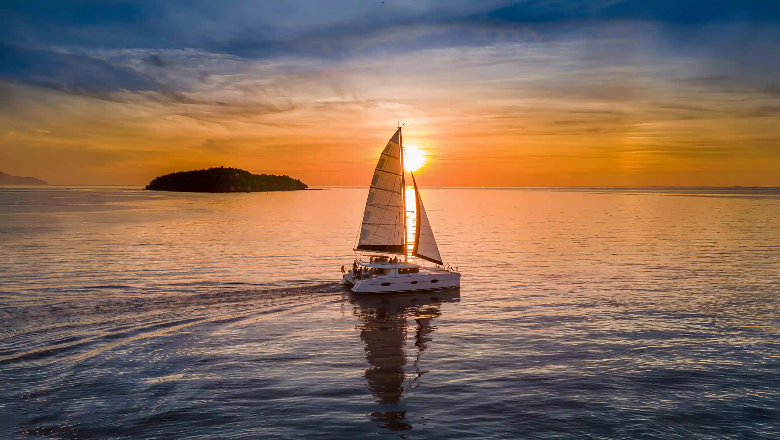 A sailing catamaran under way in clear water