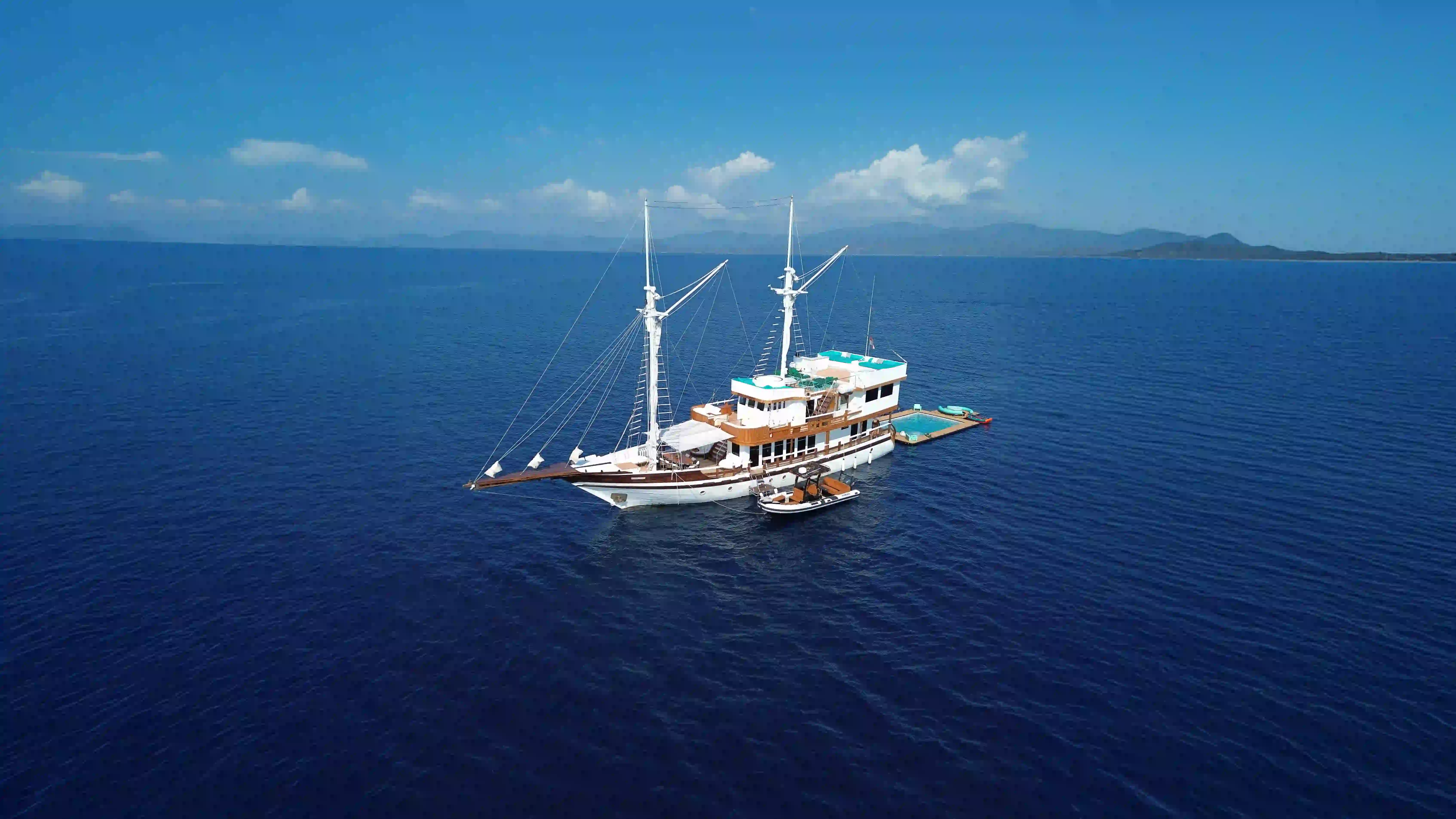 A phinisi liveaboard at anchor in calm water