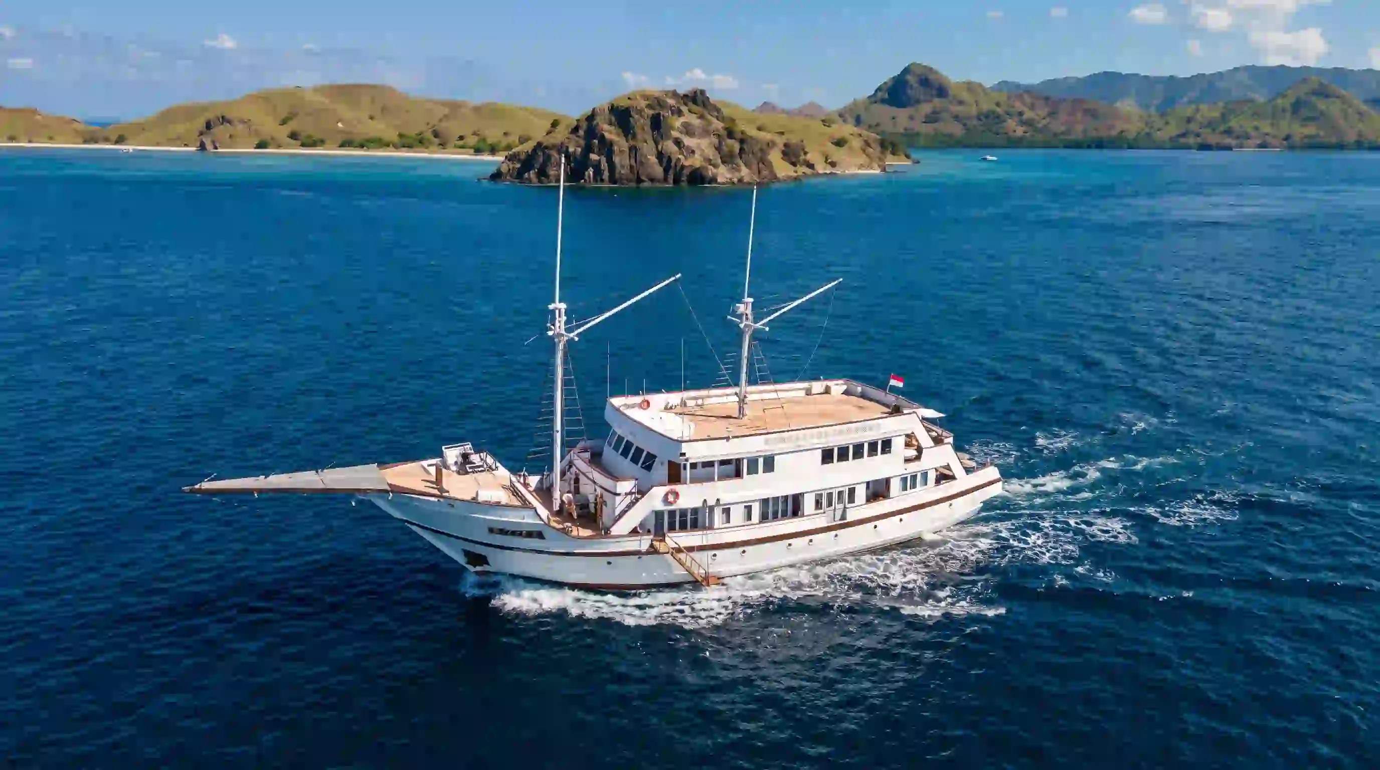 A phinisi at anchor in clear water